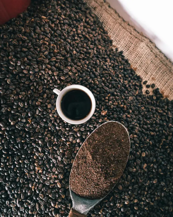 Una cuchara con granos de café tostado