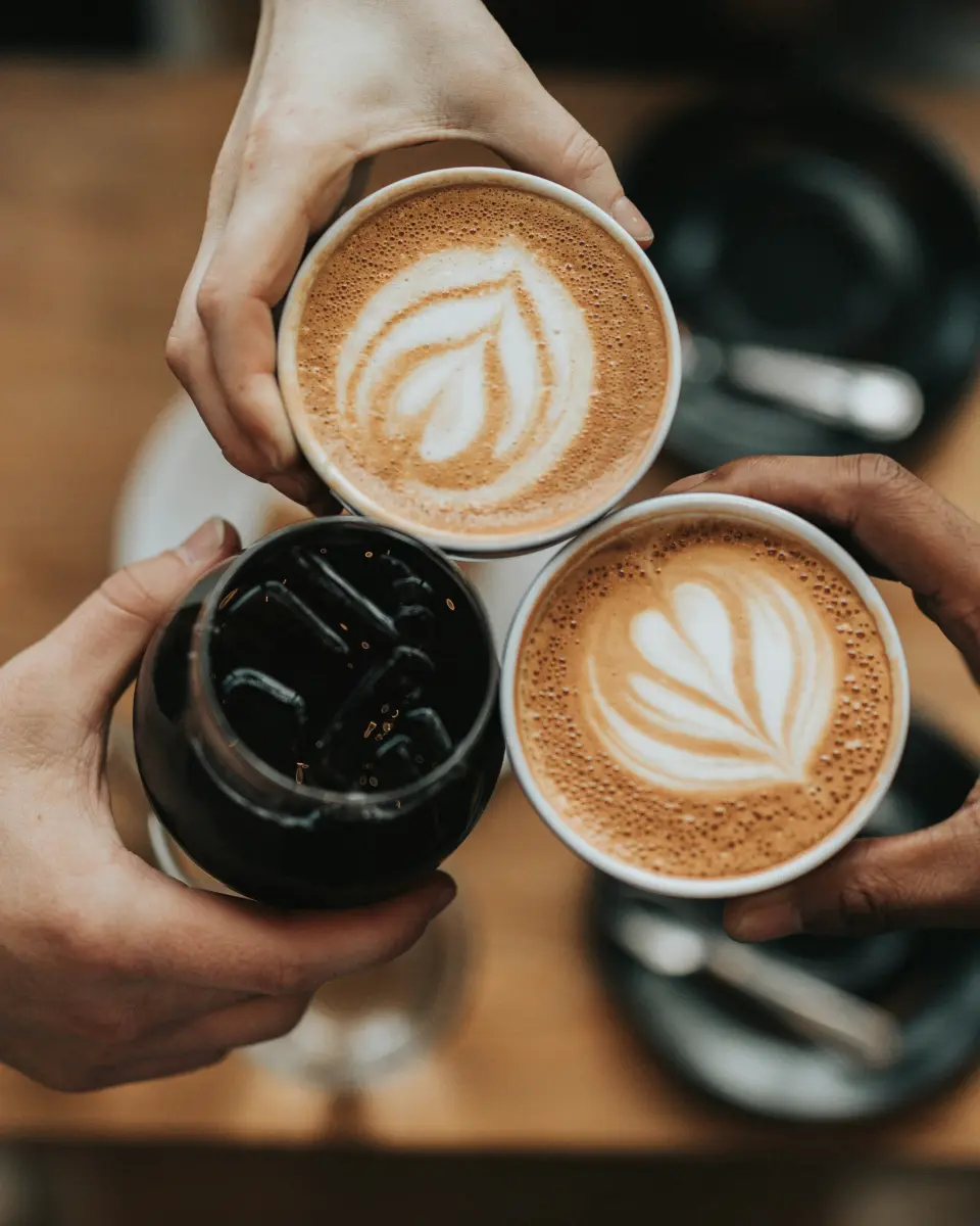 Una taza de café negro sobre una mesa de madera